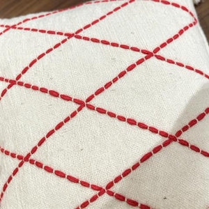 Coussin écru à losanges rouges et pompons blancs – 45 × 45 cm