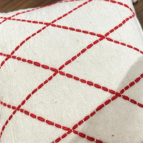 Coussin écru à losanges rouges et pompons blancs – 45 × 45 cm