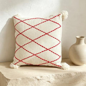 Coussin écru à losanges rouges et pompons blancs – 45 × 45 cm