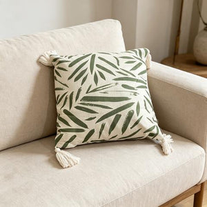 Coussin décoratif écru à motifs verts et pompons blancs