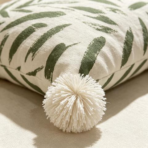 Coussin décoratif écru à motifs verts et pompons blancs
