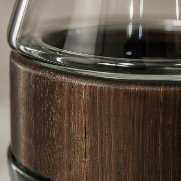 Un vase élégant associant verre transparent et bois foncé, idéal pour une décoration moderne et chaleureuse.